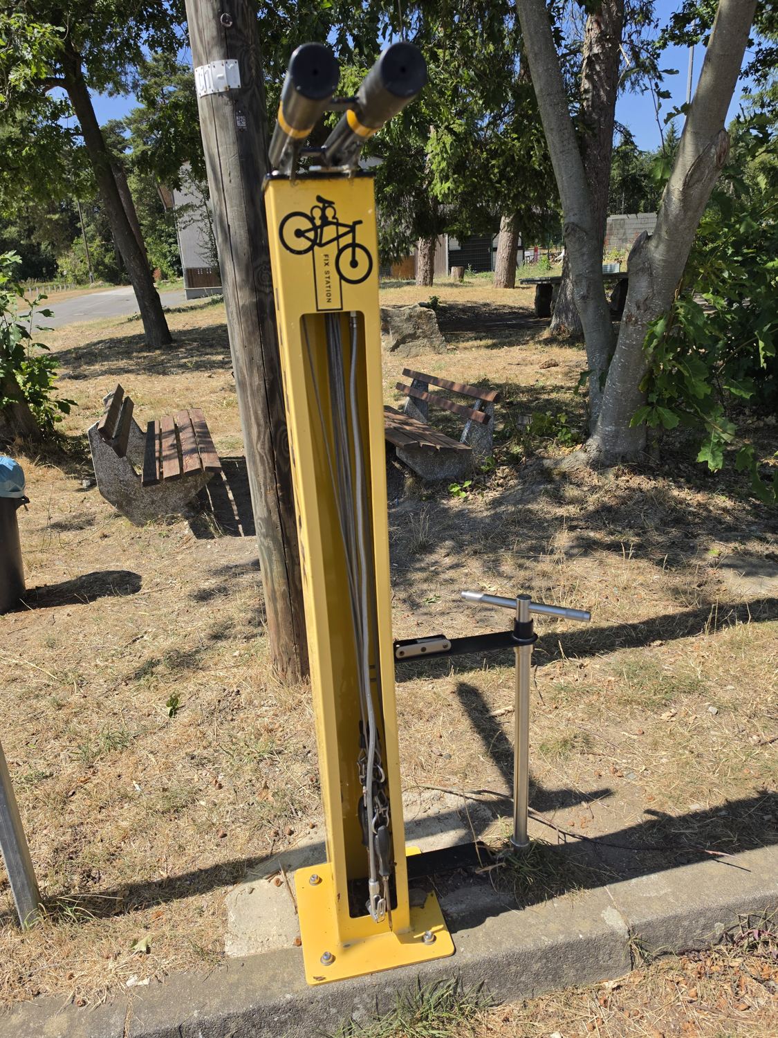 Gelbe Fix Station mit Werkzeug an Stahlseilen unter Bäumen