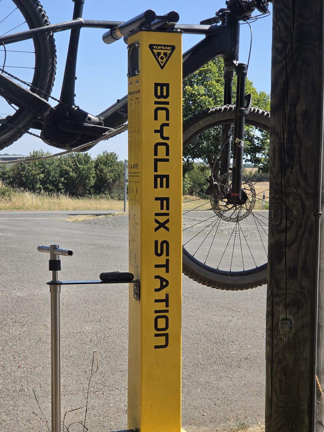 Gelbe Topeak Bicycle Fix Station mit eingehängtem Fahrrad und Reifendruck-Tabelle