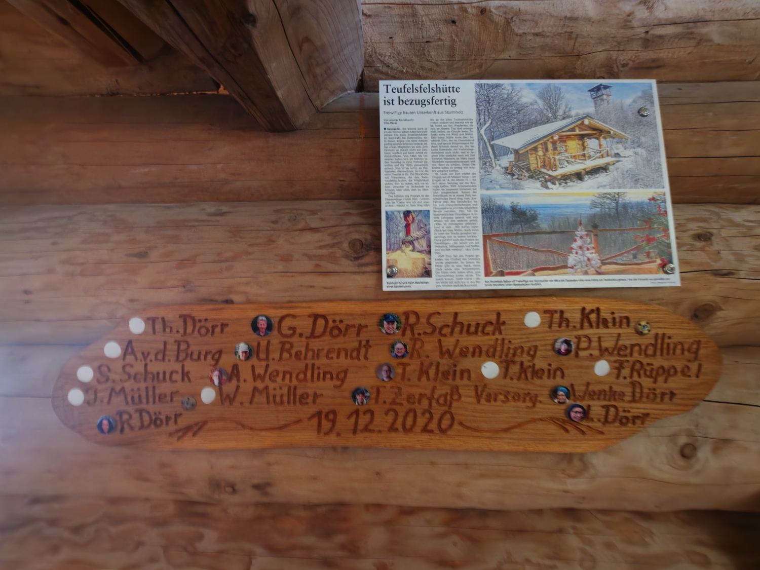 Zeitungsartikel über die Teufelsfelshütte neben geschnitzter Tafel mit den Namen der Erbauer